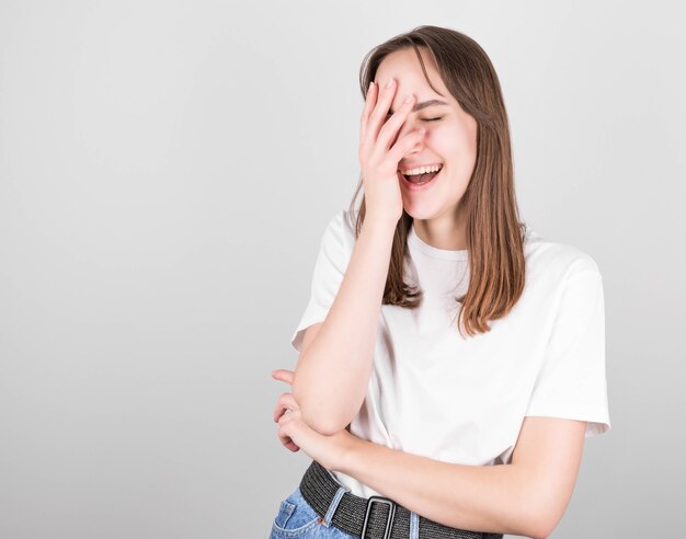 Charismatic carefree joyful friendly brunette woman in a white T-shirt and jeans loves to laugh out loud without hiding emotions