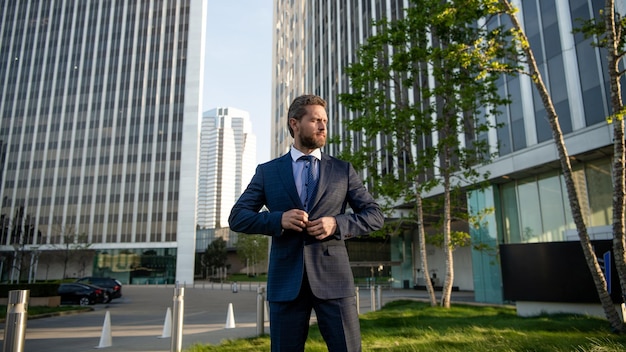 Charismatic mature businessman in suit outside the office, business.