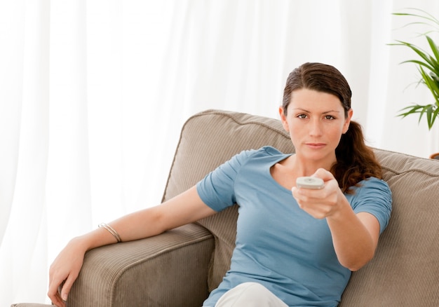 Donna carismatica guardando la televisione a casa