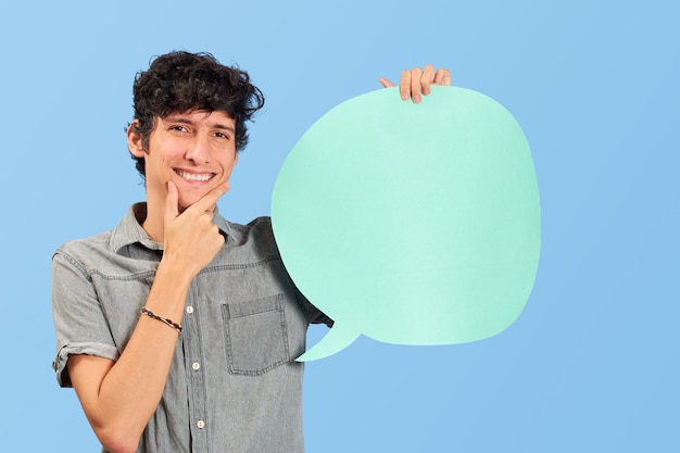 Charismatic young man with dialogue bubble on blank in blue\
flat lay