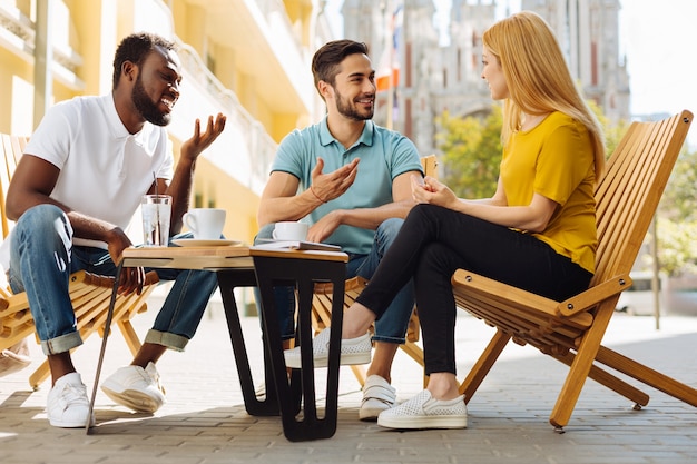 Charismatische jongeren bespreken en plezier maken in café