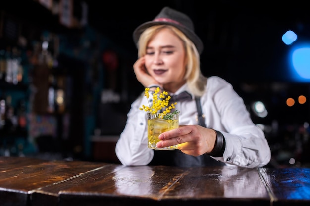 Charismatische vrouw bartending demonstreert zijn vaardigheden over de toonbank op de bar