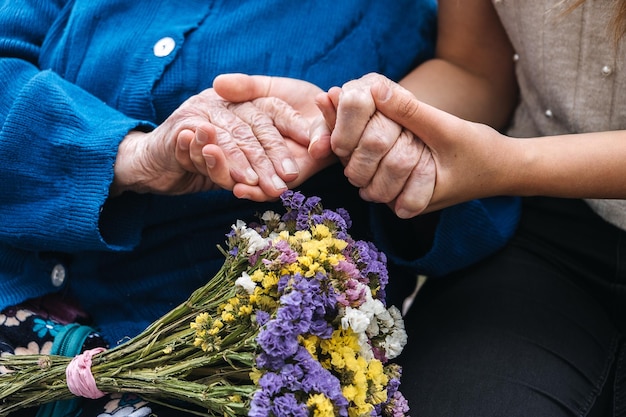 Charities for Elderly People Young hands holding old elderly senior hands Support for the seniors concept