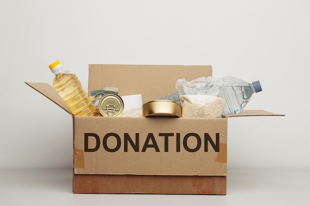 Charity concept. Open donation cardboard box with various food.