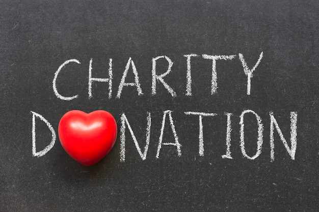 Charity donation phrase handwritten on school blackboard with heart symbol instead of O