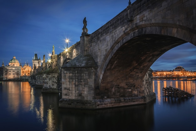 Foto charles bridge over vltava met nationaal theater onder de boog 's nachts in praag