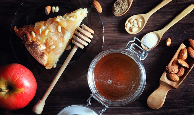 Charlotte met appels en noten. Bereiding van appel bakken met noten en honing. Dessert gebakken goederen van appels en noten met honing op een houten tafel.