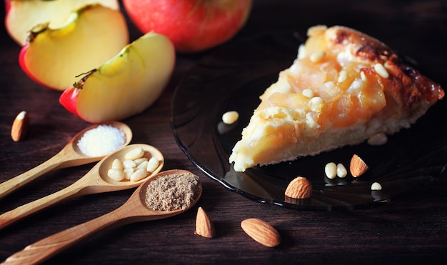 Charlotte with apples and nuts. Preparation of apple baking with nuts and honey. Dessert baked goods from apples and nuts with honey on a wooden table.