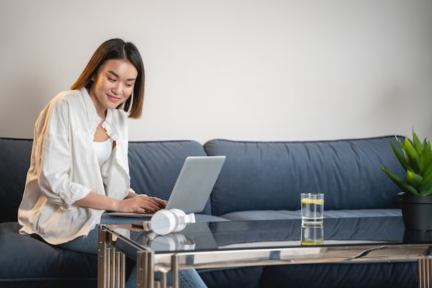 Charmant jong meisje dat laptop computer met behulp van