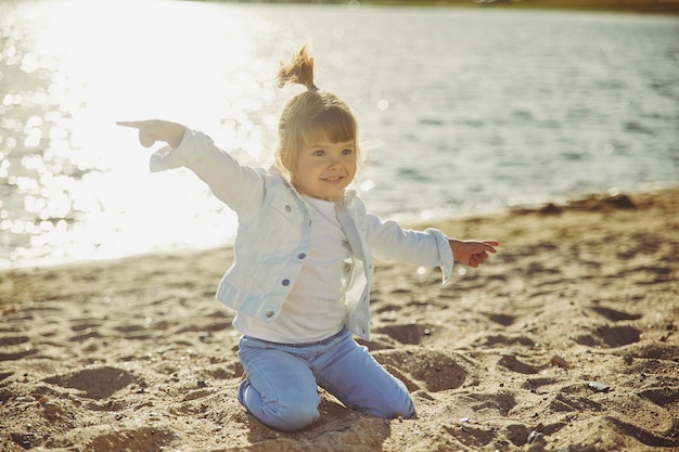 Charmant kind dat op het strand bij zonsondergang loopt