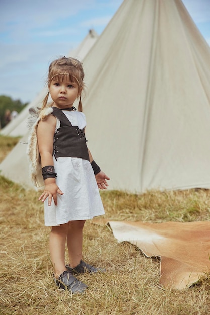 Charmant kind in primitieve kleren op het vikingfestival in Denemarken