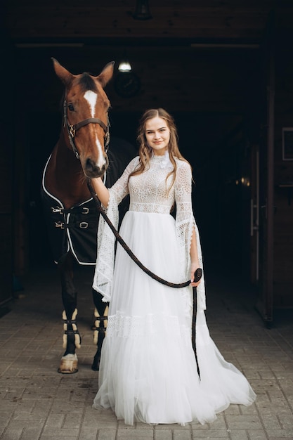 Charmante bruid in boho-stijl op een ranch met een paard