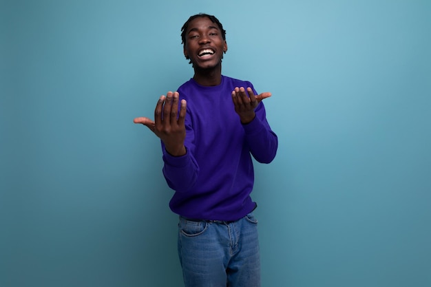 Charmante donkere jonge brunette man met dreadlocks in een blauw sweatshirt