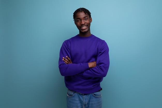 Charmante donkere jonge brunette man met dreadlocks in een blauw sweatshirt