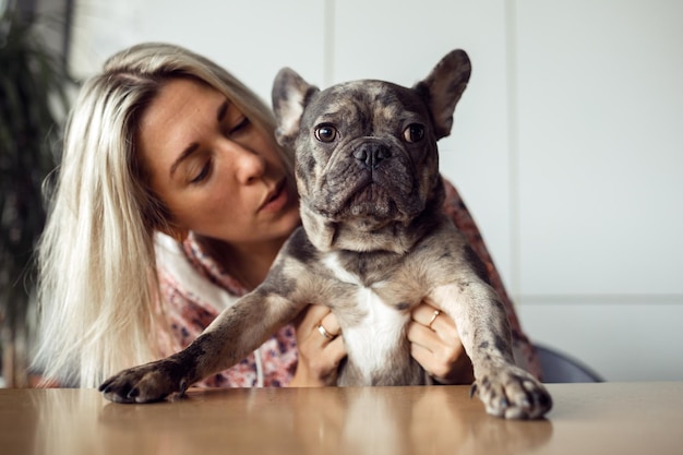 Charmante Franse bulldog luistert aandachtig naar wat zijn eigenaar in zijn oor zegt Gezonde huisdieren Gelukkige momenten Positief