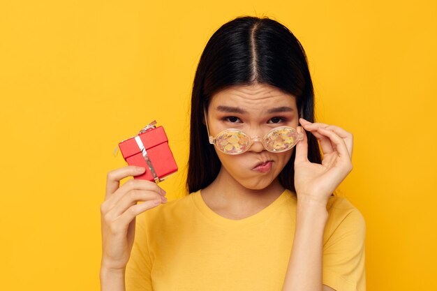 Charmante jonge Aziatische vrouw met geschenkdozen in handen leuk poseren geïsoleerde achtergrond ongewijzigd