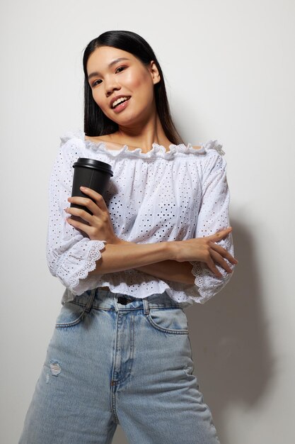 Charmante jonge Aziatische vrouw poseren met een wegwerp glas leuk drankje studiomodel ongewijzigd. Hoge kwaliteit foto