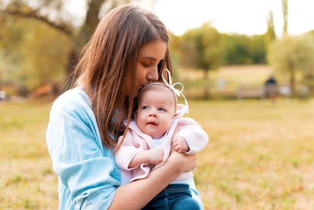 Charmante jonge moeder met haar kleine babymeisje buiten