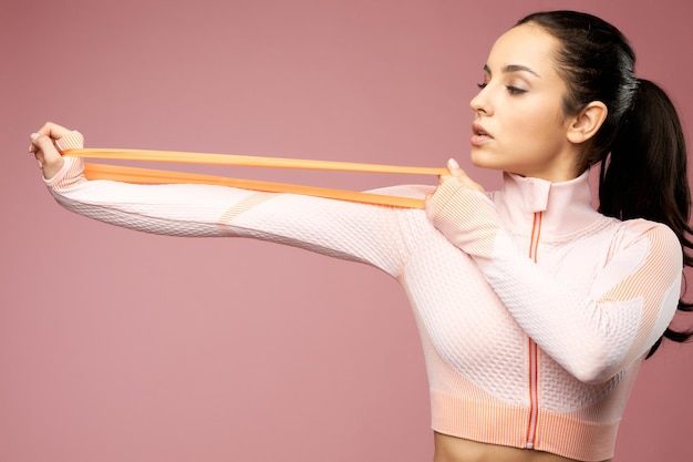 Charmante jonge vrouw in sportkleding met behulp van fitnessband