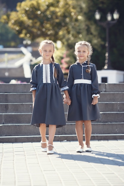 Charmante kleine meisjes in retro jurk wandelen in de stad op een zonnige zomerdag.