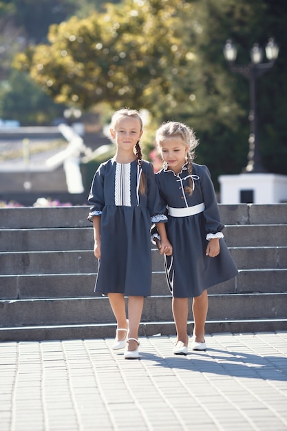 Charmante kleine meisjes in retro jurk wandelen in de stad op een zonnige zomerdag