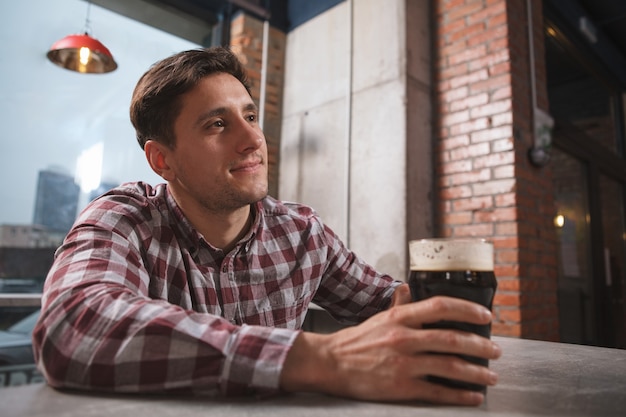 Charmante knappe man genieten van bier drinken in de lokale pub