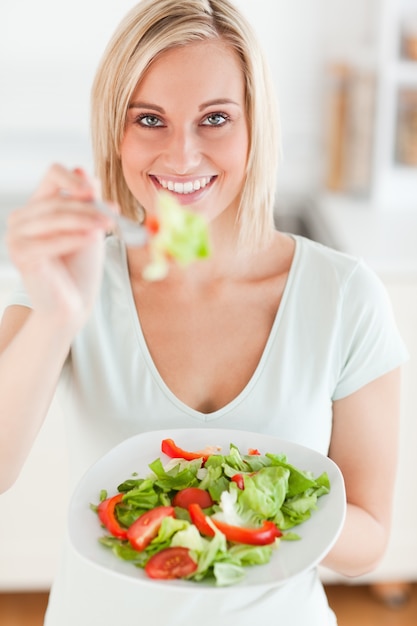 Foto charmante vrouw die salade aanbiedt