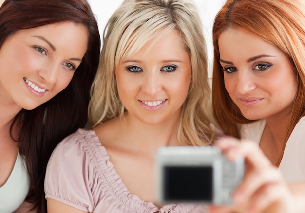 Charmante vrouwen die op een bank met een camera lounging