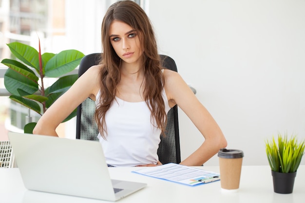 Charmante zakenvrouw zitten werken op laptop in office