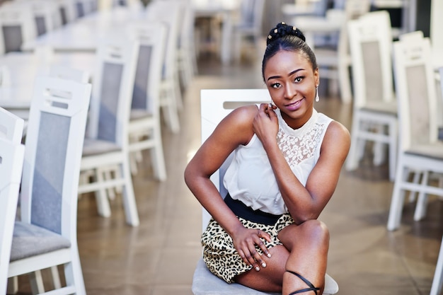 Charming african american woman in leopard skirt posing at restaurant