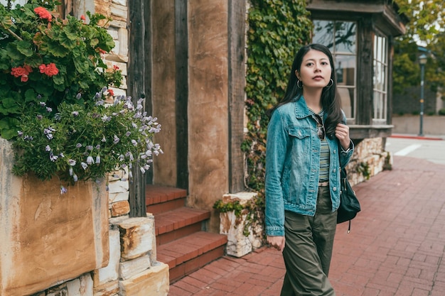 charming asian woman standing and looking to somewhere else far away in the street.