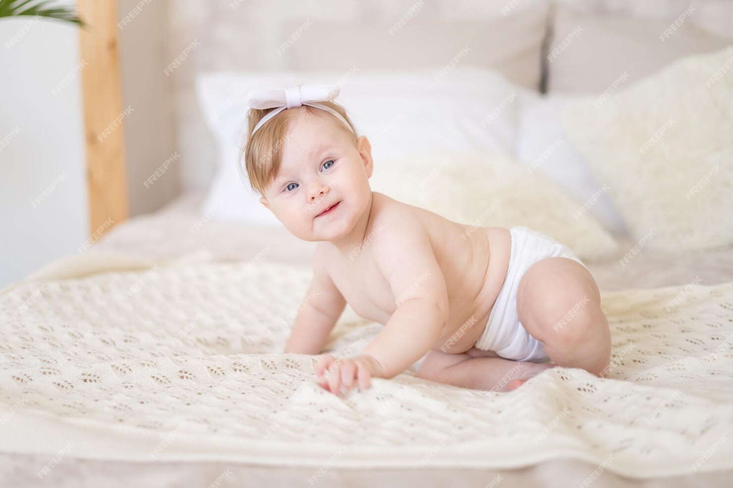 Premium Photo | A charming baby girl in diapers is sitting in a bright ...