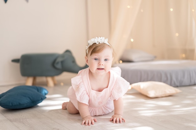 A charming baby girl is playing in a cozy bright children's room with a wigwam and soft toys The interior of the children's room Funny baby in the nursery at home