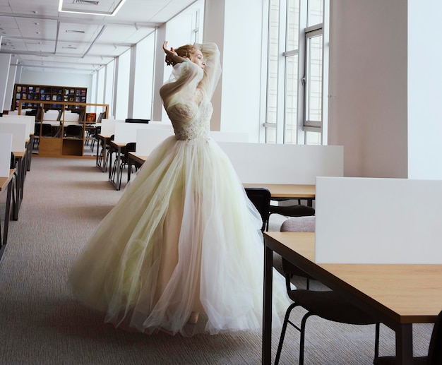 Charming ballerina went to the library to choose a new book during a break showing your stretching and flexibility