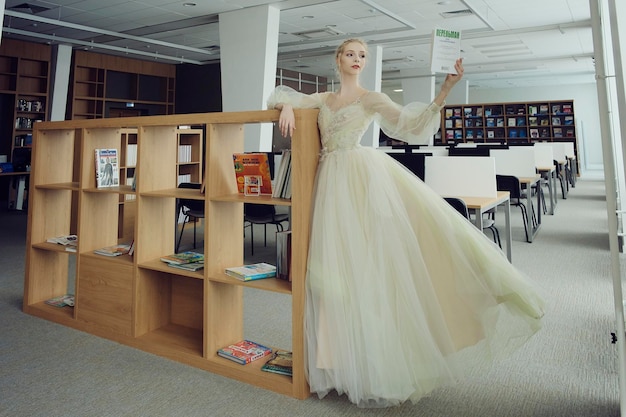 Charming ballerina went to the library to choose a new book during a break showing your stretching and flexibility