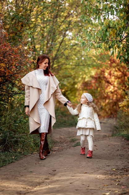 Charming beautiful mother walks with little daughter girl