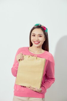 Affascinante bella pelle abbronzata donna sicura asiatica mostra borse della spesa.