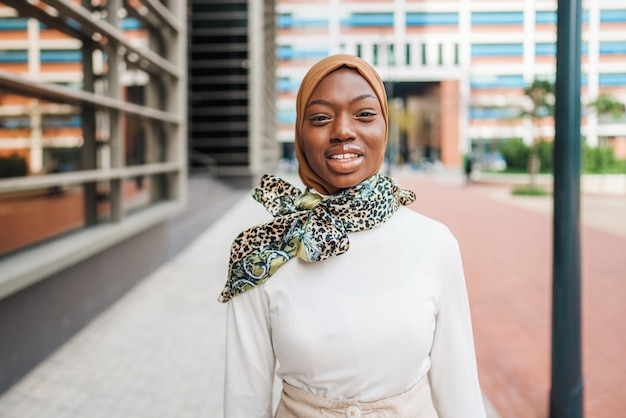 Charming black woman in muslim headscarf standing on street