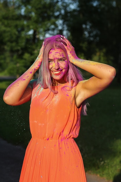 Charming blond model posing covered with a colorful dry paint 