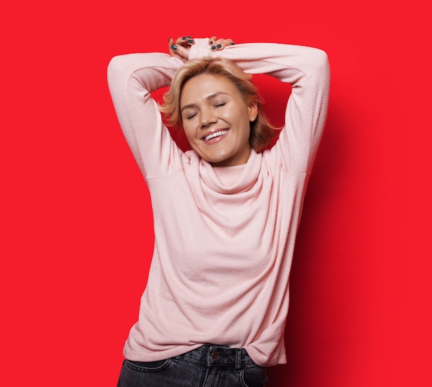 Charming blonde lady posing with hands above the head