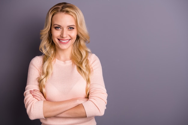 charming blonde woman posing against the purple wall