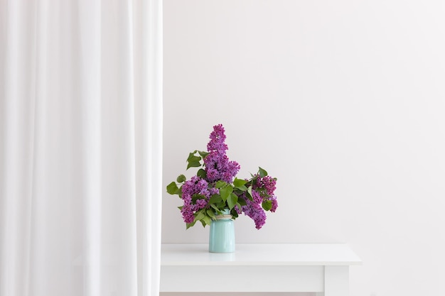 Charming bouquet of blooming lilac in vase on grey