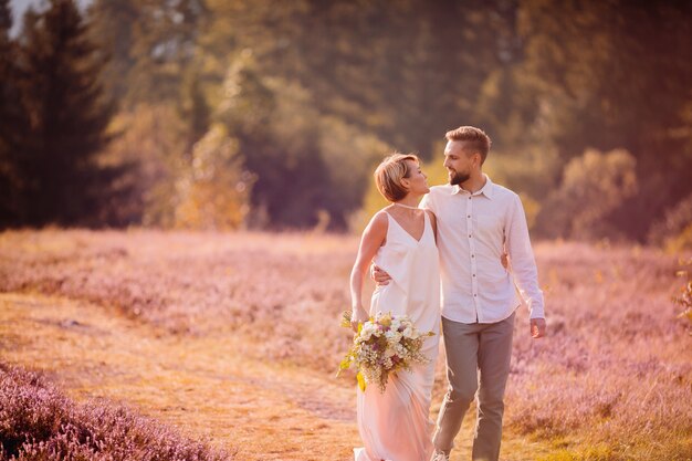 The charming boy and girl walking along field