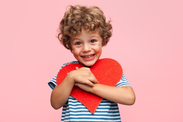 Foto ragazzo affascinante che posa con il cuore