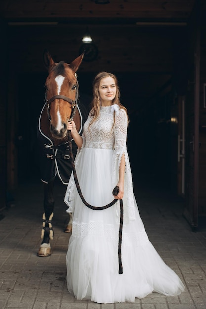 Charming bride in boho style on a ranch with a horse