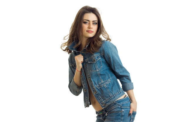 Charming brunette posing on camera leaning in jeans jacket isolated on white background