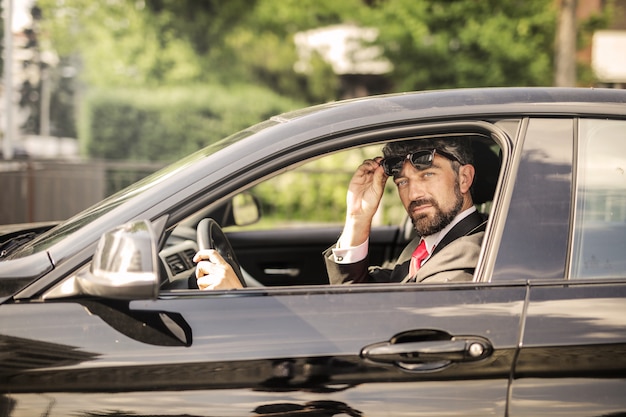 Charming businessman in his car