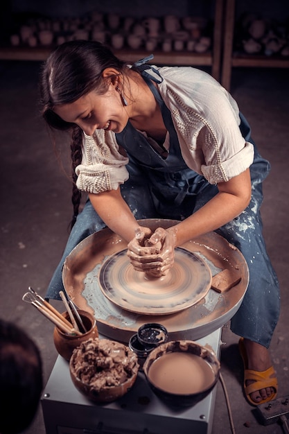 charming ceramist master at his wheel creating a new masterpiece. concept for woman in freelance, business, hobby.