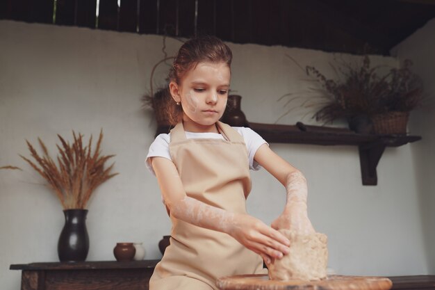 Photo charming craftsman little girl enjoying pottery art and production process