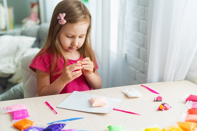 Charming cute little baby girl with soft colorful clay